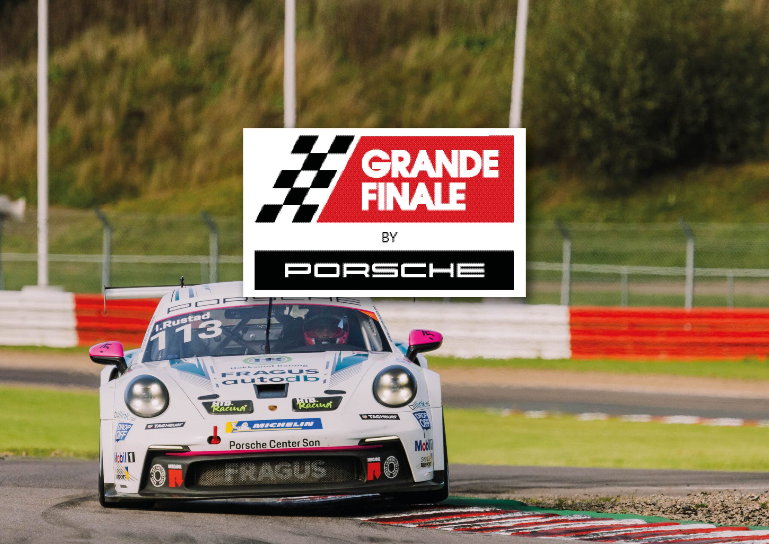 En vit Porsche-racerbil rundar ett hörn på banan med en Grande Finale by Porsche-logotyp och rutig flagggrafik överlagrad i mitten av bilden. Grönt gräs och säkerhetsbarriärer finns i bakgrunden.